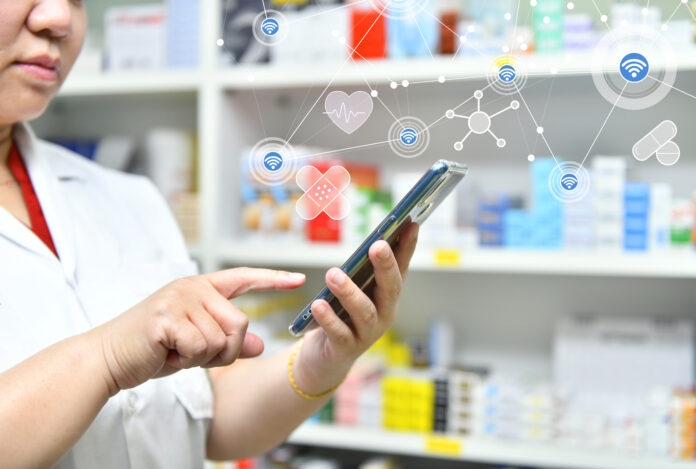 Farmacéutico que usa la barra de búsqueda de su teléfono móvil en una farmacia